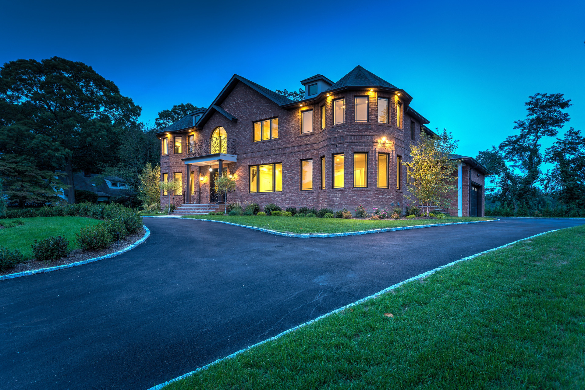 Overlooking the rolling fairways of Wheatley Hills golf course, this new brick Colonial offers 5,200 square-feet with six bedrooms, six-and-a-half baths - all exquisitely finished with only the finest in materials and craftsmanship. Standing majestically on .44 acre of professional landscaping with a circular drive, the home welcomes guests with a stunning entrance boasting a spacious portico, filigree cast-iron French doors, similar filigree balustrade, and wide brick steps.
Adjoining the Wheatley Hills Golf Course, the scenic community of Roslyn Country Club is aptly named. Its sidewalks invite pleasant strolls along its peaceful lanes with beautiful homes. Located in Roslyn Heights, this special area has access to premier shopping, parks, schools, Hofstra University, railroad (approximately 2 miles from this home) and major highways putting it within approximately a half-hour commute to Manhattan. 
Enter the two-story center-hall entrance foyer and be enthralled by the gleaming inlaid ceramic tiled floors with radiant heat that extends throughout most of the first floor. A graceful oak staircase features a filigree balustrade ascending to a second-floor balcony. The chandelier is motorized for ease in cleaning. Gorgeous moldings and fielded-panel wainscoting flow into the sun-drenched living and dining rooms (each with semicircular bay window) and into the inviting family room with an enticing gas fireplace and large triple window overlooking the golf course. Each of these rooms features oak flooring, a unique, recessed ceiling, and easy flow into adjoining rooms. The formal dining room leads into the kitchen through a sparkling butler’s pantry with lighted, glass cupboards, wine cooler, and granite wet bar.
Featuring the flooring that flows into the room from the foyer, past a powder room and guest closet, the bright and airy eat-in-kitchen has everything to wow a gourmet chef. Extensive custom cabinetry includes granite countertop, marble basket-weave backsplash, some display cupboards with glass shelves and lights, and a large center island with prep sink and ample storage. High-end stainless-steel appliances include a Wolf six-burner gas range with griddle and double-oven, a Wolf wall oven and Wolf microwave/convection, a 48-In Sub Zero double door refrigerator, and two dishwashers flanking a large sink that overlooks the golf course. A spacious and sunny breakfast area includes a planning center and sliding-glass doors to the rear patio. A staff/guest bedroom, attractive full bath, laundry room with high-efficiency appliances, and access to the attached two-car garage complete this main level.
On the second floor, the palatial master suite boasts a spacious bedroom with semi-circular bay window and tray ceiling, ample closets, and a luxury master bath with steam shower, water closet, and twin vanities flanking a free-standing tub. Also on this level is a second master suite with semi-circular bay widow and bath en suite, plus three additional bedrooms and two baths. Hardwood floors flow throughout. The full unfinished basement has high ceilings, a finished bath, and access to the rear patio. All one could want in a home is here in this fabulous, pristine brick masterpiece, ideally located and waiting to become the home of your dreams.