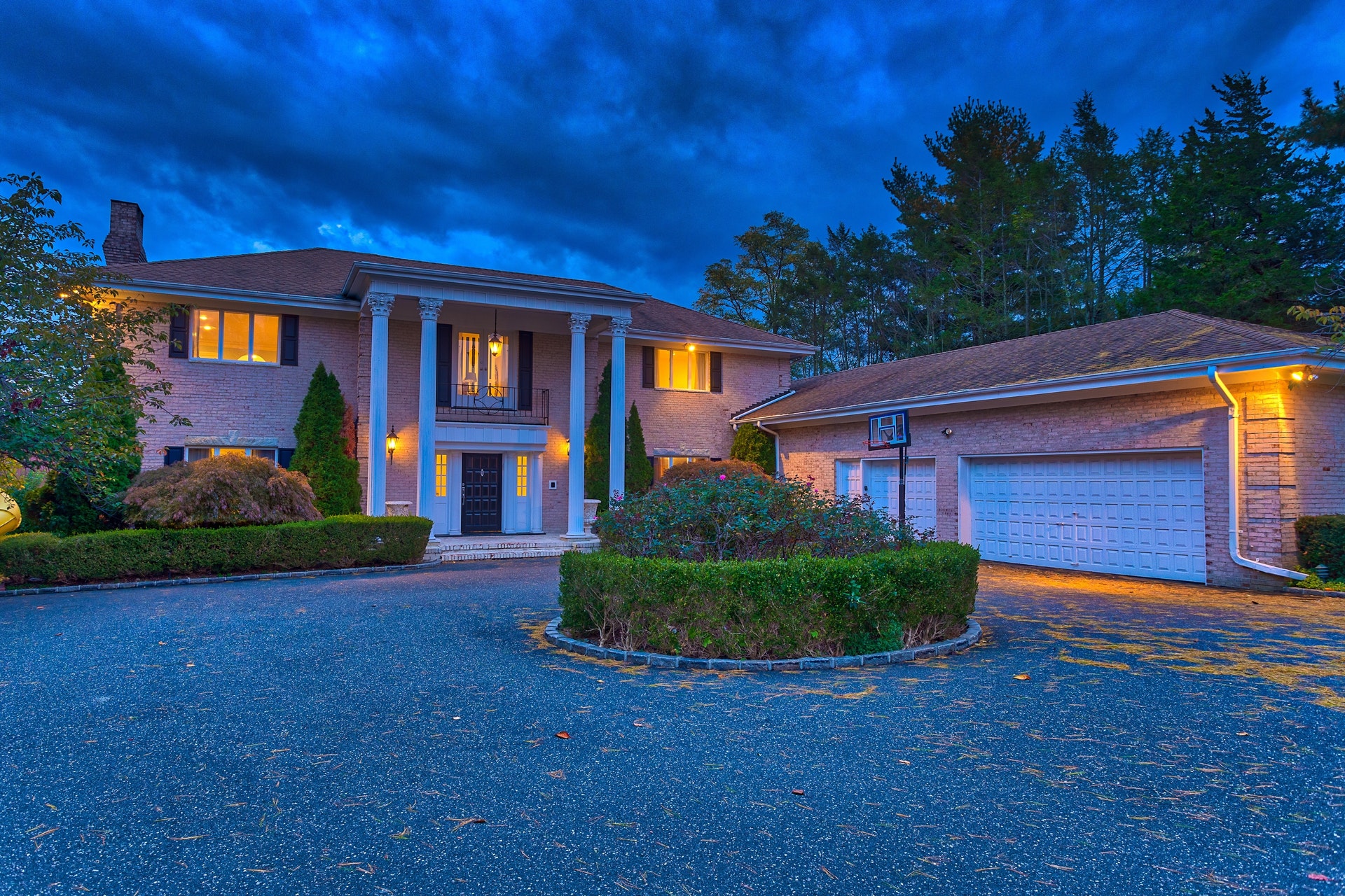 With views of the sparkling waters of Long Island Sound, just six-hundred feet away, and gentle summer breezes wafting through the trees, just feel the stresses of the day melt away as you sit with a glass of wine on your bluestone patio. Or take a dip in your swimming pool that overlooks a scenic pond. Perhaps some waterfowl will drop by for a visit. Such will be your pleasure in this marvelous home just minutes away from Manhattan. Located on a cul-de-sac road in Kings Point, this delightful six-bedroom, five-and-a-half-bath, center-hall, brick Georgian Colonial welcomes guests along a hedgerow-lined drive to a circular courtyard and imposing two-story portico with Corinthian columns.   

Offering high ceilings and sun-swept, spacious rooms, the interior is ideal for gracious entertaining with easy movement from the grand marble foyer with graceful bridal staircase and elegant moldings, into the inviting living room featuring a striking Zebra Wood gas fireplace, massive crown molding, and herringbone hardwood floors that flow into the library. Here, a paneled wall with ceiling-high bookcases matches the rich tones of a coffered ceiling while a huge triple-window floods the room with distant water vistas. Open to this area, the bright sophisticated den says, “Come and stay awhile.” A wall paneled in Macassar ebony wood frames two floor-length windows framing a giant, Caesar Stone, gas fireplace beneath a large television. The adjoining wall opens through sliders to the expansive rear patio, which overlooks the pool and pond.

Through French doors off the foyer, the chic formal dining room, with triple window and fielded panel wainscoting, opens to the spacious eat-in-kitchen. This sunny room was designed for entertaining, featuring a large workspace with sleek, granite-topped cabinetry, two separate workspaces with cooktops, a center island, and matching, full-size, two Subzero refrigerators and freezer. Tile floors flow past a planning center into the breakfast area that opens through sliders to the patio. A service hallway leads to the laundry room, full bath, side entrance, walk-in pantry, staff bedroom, and attached three-car garage.

On the second floor, the palatial master suite boasts a huge bedroom with custom rose wood gas fireplace, many closets including two custom-fitted four-season, walk-ins (one is huge), a lavish marble bath with soaking tub/shower, a second shower, and a large sauna. Also off the spacious landing are two bedrooms with baths en suite, two bedrooms with walk-in closets that share a bath. All are beautifully appointed. The finished basement offers ample space for play or entertaining with wood floors, a generous recreation room, and a large bonus room with windows between.

Great Neck is a peninsula on Long Island’s north shore known for its diverse population, cultural activities, and many high-profile residents. Valued for its proximity to Manhattan and its award-winning schools, it has been the home to such notables as Paul Newman, Francis Ford Coppola, F. Scott Fitzgerald (whose “Great Gatsby” was based on the area), Harry F. Sinclair, and Walter P. Chrysler, whose estate is today the U. S. Merchant Marine Academy. It offers all the recreational facilities, dining, and shopping experiences for which Long Island’s North Shore is famous.