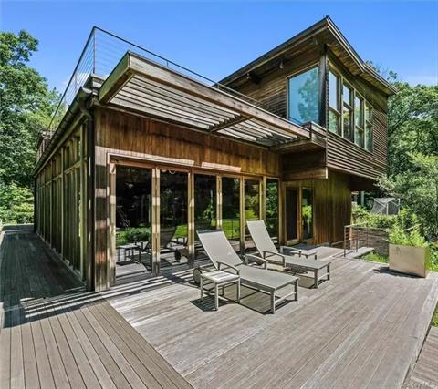 Deck off indoor pool area overlooks forest.