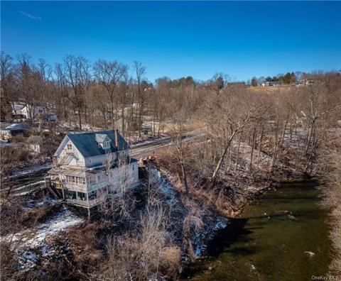 Overlooking a bend in the scenic Ten Mile River. Additional income with 3 rentals upstairs, two 1-bedroom apartments and one 2-bedroom apartment, currently rented month to month.