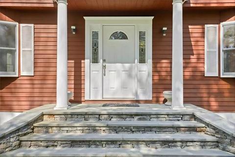 A new Bluestone walkway leads you to pillared and lit covered entry