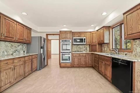 So much counter space for great gatherings. Kitchen communicates well with outside. New appliances, recess lighting , stainless steel sink with a window above. Wood cabinetry with granite countertops.