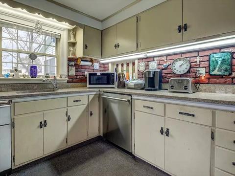 Light filled Country kitchen features built in china cabinets, and 2 pantries. Note the original glass doorknobs and once again, beautiful property views.