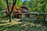 Set way back on 3.3 wooded acres, this lovely home offers peace, quiet and tons of PRIVACY. The stone & cedar exterior pair perfectly with this home&rsquo;s natural setting. A lovely brick walkway escorts you to the wide entry foyer leading to a powder rm, office/den, and a spacious family room feat. hardwood floors & a beautiful stone fireplace. Just off the family room is a large 2-car garage/workshop feat. high ceilings & convenient attic access. Be sure to check out the climate-controlled bonus room, which makes for a great home office, gym, art studio, etc. To the left of entry foyer is a 2nd living rm feat. cathedral ceilings & 2nd fireplace. Home offers a formal dining area & eat-in-kitchen, illuminated by natural daylight from skylights. Top-floor offers 3 BRs incl. master suite, ensuite & private balcony. Private patio is perfect for year-round relaxing & entertaining. This beautiful home has tremendous potential, and the large lot allows for future expansion if ever needed.