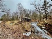 WATERFALLS!! Adorable two bedroom cabin on 1.95 acres. Quiet area. Sit on your deck overlooking the beautiful waterfalls which runs all year long. Close to NYS Hunting lands for hunting, hiking, snow shoeing, cross country skiing and snow mobiling.... needs TLC. What an imagination to make this cabin into your own special paradise. So much potential. Seller motivated. Fix up and rent as a AIR B&B. Great Investment!