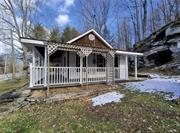 Come see this high efficiency, clean & cozy country home nestled in the hills of Sullivan County. Recent renovations make this 2 bedroom cottage really stand out. Step through the front door from the lovely wrap-around porch or enter through the sparkling kitchen equipped with energy saving appliances. The large stone fireplace in the living room anchors a rustic yet modern motif. The brand new bathroom, water heater, laundry hookups, & powerful ductless heating/AC unit are part of comprehensive updates along with new plumbing, wiring, & insulation. Some of the original hardwood has been rejuvenated while other areas were treated to all new flooring. A third door past the laundry area leads outside to a small shed & the impressive stone outcropping behind the home. To complete the thoughtful updates, a drainage system was installed at the foot of the ample driveway. This modern, efficient gem is waiting for you to fill it with love & make some memories. May also be used as an investment property.