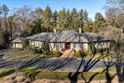 Fall in love with this brick slate roofed five bedroom sprawling ranch from the moment you enter the circular drive. Detailed finishes include wainscotting, high ceilings, hardwood floors, two fireplaces and built-ins. A welcoming entry opens to generous principal rooms designed for home entertaining. Culinary renovated kitchen highlights include sleek white and black cabinetry, granite center island and top appliances. An adjacent den is the perfect place to unwind and enjoy the view of the verdant acre landscape. Romantic primary suite offers fitted closets, a private patio  and hot tub for you to unwind. An en-suite marble bathroom is your personal spa with two vanities, free standing tub and shower. Spacious walk-out lower level features recreation rooms, remote-home office and gym. Your summer fun will be enhanced by the refreshing in-ground salt water pool, the warmth of a firepit, outdoor kitchen and shaded louvered pergola. Generator, automatic pool cover and outdoor shower.