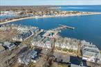 Experience ultimate luxury and impeccable design in this completely renovated waterfront condo! The attention to detail and high-quality materials used throughout are unmatched, sexy and sleek. Perched upon the second floor in one of the best locations in the development, you have a large private balcony overlooking a magnificent water view of Greenport Harbor out to the Bay! The kitchen is equipped with all new appliances, quartz countertops, marble backsplash, custom window shutters, instant hot/cold water filtration system and access to a small balcony perfect for easy access to grill! The living room is a showstopper which includes vaulted ceilings with custom wood beams, a sophisticated wood burning fireplace with marble mantle and sliders to the waterside balcony. The primary bedroom has its own access to the waterside patio and also has custom wood ceiling beams, custom closets, and an en-suite bathroom. Both the primary bathroom and guest bathroom have been gutted to the studs with all new plumbing and electric, Carrara marble showers with custom frameless shower doors, Carrara marble floors, Restoration Hardware extra wide vanities with Carrara marble vanity top/backslash. There are 6 inch modern base moldings and new doors throughout, along with custom decorative wood trim in the hallway, and full size stackable washer/dryer. Pull down stairs have been added to hatch to attic to provide extra storage. Stirling Cove is one of the most desirable complexes on the North Fork. Each unit has its own deeded boat slip (docks have been recently redone), there is a private beach, tennis/pickle ball, heated pool and its two blocks from Greenport Village restaurants and shops!! Charging stations for electric cars on site! This condo is truly a designer&rsquo;s showcase and a one-of-a-kind gem! Turnkey and ready to go for Summer 2024!!