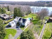 Watch the sunrise every morning at this incredible waterfront retreat in New City, NY! Completely remodeled and built anew in 1999, this expansive L-shape colonial features 6 bedrooms/6 bathrooms set on a flat 1.4 acres with unparalleled sunrise lake views over Lake DeForest! Enter into the grand double-height foyer to the main level, featuring endless sunlight and wide hallways leading to each wing of the home. Multiple living rooms, a ground floor bedroom with en-suite bathroom, chef&rsquo;s kitchen with 2 sinks, 2 dishwashers, double ovens and butler&rsquo;s pantry make this home the perfect place to entertain. The main floor also features a large formal dining room, mudroom with half-bathroom, access to the 2-car garage, and and an amazing screened porch overlooking the pool and lake. Head up either of the 2 staircases to the bedroom level, with a primary suite equipped with multiple walk-in closets and luxurious spa- like bathroom. The remaining 4 bedrooms include a junior primary suite, 2 bedrooms with Jack/Jill double-vanity bathroom, and a large bedroom that is also ideal for an office, gym, or living room. Bonus 2nd floor AND basement laundry. Down in the basement you&rsquo;ll find the additional guest suite with full kitchen, bathroom, 2 windowed bonus rooms, and access to the backyard. Custom gunite pool with jacuzzi and waterfall overlooking the lake. Tesla EV charger and solar panels included!
