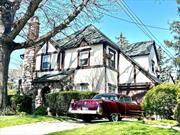 Enchanting Tudor colonial on best street mid block situated on beautiful landscaped property located in the hamlet of East Rockaway and SD#20 close to schools Enter thru custom arched door into living room with high ceilings and wood burning fireplace and formal dining room Gleaming hard wood floors lead you to grande den with vaulted ceiling and three skylights There is access to large kitchen and bathroom as well Sliding glass French doors leading to enchanted gardens with fountain Upstairs are three brs and large custom bath with soaking tub and separate shower There is a full attic with windows and a large finished basement