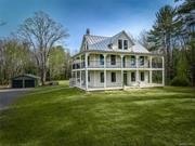 History refreshed: Following a 2-year overhaul by some of the region&rsquo;s best contractors and designers, the iconic Wilson Gray Homestead is ready for a stylish new chapter in its already storied life. The farmhouse, built in the early 1800s but dismantled and moved in 1915 from its original site at what became the Ashokan Reservoir serving New York City, is one of the few Ashokan-displaced houses still standing in the Hudson Valley. And now it&rsquo;s one of its most stunning, too. The iconic house, known for its signature wrap-around stacked verandas, has been fully renovated in a style that respects both its architectural heritage and modern sensibilities, featuring a thoughtful and consistent balance of openness and privacy throughout 3 levels of space. The ground floor features subtly separated dining and living spaces, both open to a stunning new gourmet kitchen with wonderful views from 3 sides, and featuring all-new custom cabinetry and high-end appliances including a Wolf range and paneled Sub-Zero refrigerator. The kitchen, flanked by a half bathroom and laundry area, opens to a wide covered deck taking full advantage of the private backyard and woods beyond. Upstairs are 3 bedrooms and 2 full bathrooms, including a primary suite with doors out to the second-story wrap-around porch, newly restored but with original carved fretwork. The bathrooms are stylish but far from cookie-cutter, with freestanding tubs, glass-enclosed showers and tile wainscoting. The charming and fully-permitted third floor includes a wide-open den or work space, an additional bedroom, another full bath and a remarkably sunny office or workout space with full views of surrounding mountain ranges. The list of upgrades throughout is extensive, including high-efficiency zoned HVAC systems (all electric), architect-grade replacement windows, a generator hook-up, buried electric service from the road, fire-suppression sprinklers, artfully preserved hardwood floors, and a standing-seam metal roof with historically accurate ice guards on both the house and a separate 2-car garage, also fully renovated. The restoration, already bestowed awards by local preservation groups, honors the past while providing a move-in-ready opportunity to enjoy the most modern, state-of-the-art conveniences, including proximity to popular farmers markets, wineries, and other culinary attractions, including Inness, that continue to make Kerhonkson one of the hottest destinations in the Hudson Valley. 5% SELLER FINANCING NOW AVAILABLE TO QUALIFIED BUYERS. CALL YOUR AGENT FOR DETAILS!