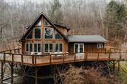 This cedar chalet overlooking looking the pristine Beaverkill River and walking distance to the famed junction pool in Roscoe, NY. Situated at the end of a private road it is an easy walk to town yet is an exceptionally private retreat. Five large bedrooms and three full baths there is plenty of room for friends and family. The finished basement is a real treat with large rec room, high ceilings and walkout exterior doors. This adds an additional 1, 200 square feet of living space. The main floor with separate but open kitchen, living and dining areas that all have direct access to the intimate back deck and the large front deck overlooking the Beaverkill. The side yard is excellent for games and entertaining with a wooden staircase all the way down to the river! This is really a great escape and is a proven short term rental. Schedule your tour today.