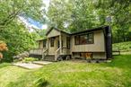 Step into tranquility with this fully renovated Mid-Century gem tucked away on a private drive. Nestled on 5 acres of wooded bliss, this home offers the perfect blend of privacy and nature. Enjoy the serene surroundings from your brand new deck and porch, where every sunset feels like a moment of pure magic. With a finished basement offering additional space for entertainment or relaxation, this home is a true sanctuary for those seeking tranquility and style. Welcome home to your peaceful retreat.