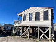 Re-built after Sandy. Adorable Cottage overlooking Bay and raised on loft pilings. 13K Artisan Well system for water. 2 Finished sheds with electric. 100 foot boardwalk. Flood Insurance is around $2500. Amazing water views, very private location. A million dollar water view! Great investment, or to keep as weekend getaway. A must see! Sold as Is.