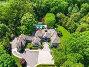 A sweeping drive leads to this cedar shake, Hamptons-style estate sited on 2+ magnificent, lush, landscaped acres in one of Armonk&rsquo;s most coveted locales. This elegant five-bedroom home is imbued with style and fine craftsmanship, apparent as you stroll through gracious rooms. The foyer opens to formal spaces segueing to the gourmet kitchen with breakfast room and family room boasting an impressive floor-to-ceiling stone fireplace. A den looking into the screened-in sunroom with fireplace, opens to the idyllic backyard. Set apart from the main living spaces is a separate first floor three-bedroom suite. Completing this level, you&rsquo;ll find a study, laundry, and mudroom accessing a 3-car garage. The upper level offers a private primary suite with balcony, dressing room and spa bath with steam shower. Passing through the loft is a lounge, full bath, and bedroom. The lower level offers a large rec room, and for the wine and cigar enthusiast, a walk-in wine room with seating for four. The backyard, a highlight of the property, encompasses an oversized patio with built-in stone kitchen, heated pool with spa and stone walls amidst verdant greenery. An exceptional offering minutes to town and schools. 50 minutes to NYC.