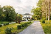 A sprawling farmhouse set on ten acres with a pond and heated saltwater pool, perfectly situated in the Hudson Valley between Rhinebeck and Hudson. Set back from the road down a long, circular driveway, the home is framed by willow trees and blooming perennials, and the whimsical covered porch is reminiscent of iconic Southern architecture. Enter through a mudroom into a wide, gracious foyer where the original tin ceiling is still perfectly intact and painted a luminous glossy blue that sends natural light dancing about the space. A classic four-square configuration, you&rsquo;ll find four rooms off of the central hall. The kitchen sits in the northeastern section of the south-facing home, it is designer renovated perfection with custom, inset cabinetry and a plate rack hung above the farmhouse sink that looks to be plucked right out of a Cotswolds cottage. You&rsquo;ll find a Wolf range, loads of storage, integrated appliances and a large center island. The kitchen leads into the dining room where a Brooklyn artist has handprinted a mural to cover the walls and painted the ceiling a bright and unexpected pop of green. Across the central hall lies a light filled, large living room with build in cabinetry and a woodburning stove. This area leads into the study, painted a moody blue which contrasts beautifully with the bright home. Upstairs, four well-sized bedrooms. The primary suite features exposed beams on the ceiling and a wonderfully sizable walk-in closet. The ensuite primary bathroom has a soaking tub, a separate shower lined in handmade tiles, and jack-and-jill sinks. Two additional bedrooms share a full bath off of the hallway, and another ensuite bedroom lies at the back of the house next to the laundry room. The magic is in the details here, with hardware from Waterworks, unlaquered brass light switches from Forbes and Lomax, and vintage lighting sourced primarily from Italy. Brand new mechanicals. Outside, a sundrenched backyard is the perfect backdrop for the heated, gunite, saltwater pool overlooking a beautiful pond. The ten acre parcel is private and wonderfully dynamic with lawn, woods and water. 2h to NYC and 15m to Amtrak and in the Red Hook school district, this house is pure Hudson Valley charm.