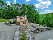 Discover your own 61-acre sanctuary, accessible by a private bridge leading to this custom-built contemporary home. This 3-bedroom, 2-bath retreat boasts an open floor plan, a chef&rsquo;s kitchen with concrete countertops, and Jenn-Air stainless steel appliances. The living area impresses with a bluestone hearth fireplace, cathedral ceilings, and a sleek staircase. A heated full basement with a fireplace offers endless possibilities. The wrap-around patio is perfect for outdoor gatherings, and the 3+ car garage with electricity and water adds extra convenience. Explore trails, wildlife, caves, and hunting stands-all just 2.5 hours from NYC and close to Delhi, Oneonta, and Cooperstown.