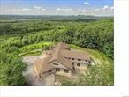 HUGE PRICE DROP! .. CALL YOUR CONTRACTOR and interior designer and bring your dreams to take this 10, 300+/- sq ft AS -BUILT home to completion!!  Imagine living on a grand bucolic 12.9 ACRE estate with UNPARALLELED SWEEPING VIEWS OF THE WARWICK VALLEY & BEYOND! This is your OPPORTUNITY to create a home with PRIME WESTERN VIEWS surrounded by THOUSANDS OF ACRES OF PROTECTED AND UNDEVELOPED NATURE bordering the Appalachian Trail!  ....  4, 700 +/-SQ FT of ONE-LEVEL LIVING with a MAIN FLOOR PRIMARY SUITE w/large Library/Office, huge ensuite bath; walk-in closet and walk-out to PRIVATE covered porch to soak in the views; 2 large additional bedrooms each with an ensuite bath, additional half bath with room for first floor laundry, a MASSIVE light-filled chef&rsquo;s kitchen with walk in pantry, butler&rsquo;s pantry and space for a huge center island; dining area, large overhead door that allows for seamless indoor/outdoor living; a large open living room with stone wood burning fireplace...NOT ENOUGH SPACE? EXPAND to the SECOND FLOOR for ANOTHER 5, 650+/- sq. ft of living space for MULTI-GENERATIONAL LIVING with a large game room/plumbed wet bar, plenty of room for additional bedrooms and anything you can dream!! ... This fantastic home has soaring ceilings and oversized Anderson windows throughout; a 3-floor elevator shaft; a fireproof vault; indoor parking for 4 cars; rough plumbing; rough lightening protection; rough electric; staff housing set up plan on the lower level; walk-out basement and more! ...Thoughtful design and quality construction throughout including hurricane straps and earthquake specs; architectural shingle roof, brick ledge, massive car-port, main level gas taps for several supplemental gas fireplaces, fast-trac synthetic PUTTING GREEN; lawn irrigation, a summer kitchen PLUS space for a pool. ... Have it all in sought after Warwick, NY and create your secluded hilltop and private WARWICK DREAM ESTATE! PARTIALLY PRIVATE GATED ROAD offers security and total SECLUSION! Close to the shops & restaurants of the vibrant Village of Warwick and the boating/restaurants of Greenwood Lake! .. Warwick Valley Central School District! OWNER FINANCING AVAILABLE to QUALIFIED BUYERS. ... PROOF OF FUNDS/PRE-APPROVAL REQUIRED FOR ALL SHOWINGS! SELLER FLEXIBLE ON PRICE! Possible conversion for town approved business/commercial or other use - Zoned MT. Additional Information: Amenities:Storage, ParkingFeatures:4+ Car Attached. ***SELLER FLEXIBLE ON PRICE***