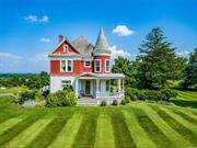 Embrace the charm and grace of a Queen Anne style masterpiece nestled on 12.37 acres of historic Hudson Valley farmland, at the Village of Athens edge. This architectural gem is a testament to timeless design, featuring classic elements such as a distinctive turret, wood shingles, and a roof adorned with multiple gables. Approach the home and be welcomed by a rounded covered wraparound porch, inviting you into a sanctuary of original details including unpainted wood moldings, wood floors, high ceilings, and leaded glass windows that frame breathtaking views of the landscape and serene pond. Step through the entryway with its beautiful beveled glass doors and vestibule, leading to a side hall staircase boasting an original balustrade from the period. The front living room and den are seamlessly connected by elegant pocket doors and a wood burning fireplace, perfect for intimate gatherings or quiet relaxation. Upstairs, discover three bedrooms and a generously sized bathroom, alongside a walkup unfinished attic offering endless potential for expansion or customization. The updated kitchen pays homage to the home&rsquo;s heritage with a farmhouse sink, beadboard ceiling, and large pantry complete with laundry facilities. Stainless steel appliances add modern convenience while maintaining the charm of yesteryear. Outside, enjoy the expansive grounds featuring a picturesque pond, 3 large barns, and panoramic views of the Berkshire Mountains. A stone patio invites outdoor dining and relaxation, making it an ideal setting for entertaining amidst the natural beauty of the Hudson Valley. Don&rsquo;t miss this rare opportunity to own a piece of history where elegance meets tranquility. Schedule your private tour today and envision the possibilities of calling this remarkable property your home.