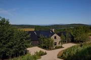 Stretching across the top of 29 wildflower-blanketed acres on the southern ridge of Winchell Mountain, with commanding Catskills views, lies High View Farm. Inspired by the rolling farmland & expansive blue skies of this very special part of the Hudson Valley, the Architectural & Interior Design duo HallidayGreer collaborated with Architect Graydon Yearick & LaGuardia Design Group Landscape Architects to create a one-of-a-kind living experience. Using sustainable natural materials & state-of-the-art building technology, High View Farm is a perfect synthesis of contemporary modernism & rural barn. Working primarily with local artisans, they have created the ultimate combination of comfort & understated luxury. Relying on the endless power of the sun & the constant, cool temperature of geothermal energy they&rsquo;ve realized a passive, architecturally-inspired EcoLux compound that will excite and endure for generations.  The 5900 sf, 5 BR/5 BA main house has 3 primary suites and 2 additional ensuite guest rooms. The baths are all appointed with Waterworks fixtures & custom cabinets. The bedrooms, all with spectacular views, are generously proportioned with custom millwork closets with oak interiors. The kitchen is a chef&rsquo;s dream with an AGA Mercury induction stove, a Thermador fridge, an appliance pantry, 2 dishwashers, full butler&rsquo;s pantry with wine refrigeration, and a Miele integrated coffee system. The great room has a masonry fireplace & dining for 14 people. The ground floor has a Tonal Smart personal training machine, free weights, a yoga/stretching area, surround-sound cinema, and a cedar sauna. The piece-de-resistance is the four season indoor/outdoor room with a wood-burning fireplace...a dream for entertaining in a country home.  The 50 x 11 ft. saltwater gunite infinity pool, w/sun-shelf & tub spa, overlooks Stissing Mtn. and has a 425 sq. ft. heated/cooled pool house with a live green roof, full kitchen & bath, & lounge/sleeping area. It&rsquo;s united to the pool by floor-to-ceiling sliding glass panel doors running the length of the pool. A lovely fire pit area for cooler summer & autumn evenings is just past the pool and up the ridge from the built-in BBQ. Closer to the main house, with its own wood-burning built-in BBQ, is the Maple Grove; another idyllic outdoor moment for more elaborate summer parties & alfresco dining. There are 2 additional structures on the property. First, a 30 x 40 mortice & tenon barn with pine & oak hand-hewn beams assembled by local Connecticut barn builders, with room for 2 cars, and a hayloft easily convertible to additional living space. Second, an atmospheric potting shed, inspired by an outbuilding on the grounds of the Parrish Art Museum in Southampton, NY made of pine & clad with perforated stainless steel...a sculptural solution to a utilitarian need.  Among the many eco-lux features are fumed white oak wide plank flooring, radiant floor heating, forced geothermal cooling to maintain absolute climate control, ultra-efficient top-quality windows throughout, sustainable radiata pine Abodo siding, and an aesthetically pleasing Tesla solar tile roof that generates almost 20KW of electricity-enough to power the whole property. It also has smart home features like programmable solar roof power generation distribution control, 3 car-charging connections, remote-controlled audio sound system, landscape lighting, window shades, security cameras & automated entry gates.  The home comes fully furnished w/bespoke soft furnishings, and fully outfitted, from luxurious sheets to elegant knife sets, all displaying the designers&rsquo; impeccable style. The interiors blend European & American classical, modernist, & contemporary pieces (primarily sourced from local antique dealers & Hudson Valley craftsmen) in a palette that reflects the rich colors & textures of the surrounding landscape. High View Farm...Not that far from everywhere but a world away is a homage to the rich history and diversity of the area&rsquo;s rural farming community with an equally engaged commitment to the future.