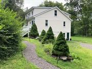 Located in the Town of Washington, a few minutes to the Village of Millbrook, this recently renovated farmhouse is situated on one of the most picturesque country roads in the area and is surrounded by a diverse array of mature trees. Spanning approximately 2 acres, the property offers ample space for outdoor activities and a sense of privacy. Step inside to find an attractively updated interior, blending modern amenities with classic farmhouse touches. The main floor features a bright and expansive +/- 18x40 feet living/dining room, filled with natural light and centered around a beautiful wood burning marble fireplace. Sliding doors open to a southern-facing deck, offering serene views of the garden for relaxation or outdoor dining. The fully renovated kitchen includes sleek quartz countertops and a stylish tile backsplash. A convenient half bath is nearby. Upstairs, a spacious primary ensuite bedroom offers comfort and privacy, alongside a second ensuite bedroom ideal for guests or family members. The lower level adds further functionality with a good-sized, partially finished basement which includes a laundry, utility room, and a full bath and an additional flexible space for a home office or family room. A potential mud/boot room with outside access to the parking area enhances practicality and organization. Outdoors, the property features an inviting outdoor dining area shaded by a beautiful Japanese maple tree, perfect for enjoying meals al fresco in a picturesque setting. Nearby, a fire pit is all set up for the chillier nights or just to relax. Whether you seek a tranquil home or a place to entertain, full time resident or weekends only, this property delivers. Minutes to Amenia, very close to trains.