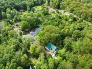 Privacy Abounds â€“ A Hidden OasisNestled on over 13 private acres in the Pine Bush School District, this custom-built retreat offers unmatched tranquility and luxury. A grand entrance welcomes you into an open-concept design with soaring cathedral ceilings adorned in natural knotty pine.Wake up to breathtaking lake views from the primary suite, complete with a cedar-accented walk-in closet and spa-like ensuite featuring twin shower heads and a private hot tub. Three additional bedrooms share a luxurious bath with a soaking tub, while sliding glass doors lead to a secluded deck.Designed for the culinary enthusiast, the expansive kitchen boasts two stoves, a double-height island, and abundant storage. Overlooking the main living space, the loft area offers three versatile roomsâ€”ideal for additional bedrooms, an office, or a creative retreatâ€”along with a full bath.Radiant floor heating spans the main level, complemented by ductless splits for year-round comfort. Just 74 miles from NYC, 16 miles to the casino, and 25 miles to Bethel, this private escape offers the perfect blend of seclusion and convenience.Your serene retreat awaits.