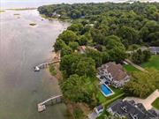 Attention Boaters! Nestled in the heart of historic Setauket, this Hamptons-style residence offers an unparalleled waterfront living experience. Poised on a serene and private lot with stunning water views on three sides, this exquisite property boasts a rare 160 feet of beachfront on Conscience Bay, making it a true waterfront oasis. This grand estate features six generously sized bedrooms, providing ample space. The primary suite is a haven of relaxation, complete with a luxurious en-suite adorned with upscale finishes and Kohler and Restoration Hardware fixtures, setting the stage for ultimate pampering. In addition to the primary en-suite, an additional two and a half well-appointed bathrooms cater to the comfort and convenience of all. Designed to meet the demands of modern living, this home features dual offices, ideal for those who seek a quiet and productive workspace. Rich hardwood floors grace the living areas, exuding elegance and warmth throughout the home. A double-sided fireplace adds an element of coziness, creating a perfect ambiance for gatherings and intimate moments. The gourmet chef&rsquo;s kitchen is a culinary masterpiece, equipped with top-of-the-line Thermador appliances and an oversized center island, providing ample room for meal preparation and casual dining. Perfect for hosting elaborate gatherings, the kitchen opens to a gracious dining area and offers seamless access to the outdoor screened porch. Step outside to discover your own private paradise, featuring an in-ground heated saltwater pool, where you can bask in the sun or take a refreshing swim with views of the sparkling bay. The meticulously landscaped grounds extend to a rare private dock, offering direct access to the shimmering waters, making this property a boater&rsquo;s dream. In addition to the beachfront, this property includes the rare benefit of deeded beach access, ensuring even more opportunities for seaside enjoyment. A private boat ramp provides convenient access for water activities, creating an idyllic waterfront lifestyle. Association dues for the deeded beach and boat ramp are $250/year. The timeless appeal of this residence is highlighted by its soaring two-story foyer and vaulted cathedral ceilings, creating an ambiance of grandeur and sophistication. The location provides a serene and peaceful environment, offering a sense of quiet retreat while still being in proximity to the rich historical charm of Setauket.