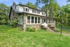 Welcome to this one-of-a-kind, 3-bedroom, 2-bath stone cottage, beautifully set on 1.8 acres of picturesque land. Imagine unwinding on the enclosed porch, surrounded by the serene beauty of nature. This home boasts stunning hardwood floors and exposed beams throughout, exuding rustic charm. The abundant natural light adds warmth to every room. Upon entering, you&rsquo;re welcomed by a spacious living room, complete with a cozy wood-burning stoveâ€”perfect for chilly evenings. The adjacent dining room offers a wonderful space for gatherings and a full bath on this level adds convenience. The large eat-in kitchen is a chefâ€™s delight, featuring a stainless-steel refrigerator, granite countertops, a central island, and custom-built cabinets that provide ample storage. Ascend to the upper level to find a charming sitting room, ideal for relaxation or a quiet reading nook. The primary bedroom is a true retreat, with private access to a full bath that includes a whirlpool tub and a cedar shower. Two additional generously sized bedrooms offer comfort and space. Outside, a large circular driveway and a 2-car heated garage add to the homeâ€™s functionality and convenience. Recent updates include new gutters, French drains, new insulation and a vapor barrier in the crawl space, a new liner for the chimney, a new oil tank, and a new washer. Beautiful wood floors under the carpet upstairs. This home effortlessly combines comfort, craftsmanship, and modern functionality, making it the perfect sanctuary. Experience the best of the Hudson Valley and the Village of Washingtonville, with easy access to shopping, restaurants, hiking and biking trails, wineries, breweries, farms, golf courses, state parks, and the excitement of Legoland. Additional Information: HeatingFuel:Oil Above Ground, ParkingFeatures:2 Car Detached,