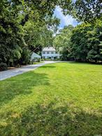 Classic colonial home on Conscience Bay with deepwater dock and beach frontage. Large eat-in kitchen, fireplace in front-to-back living room with pegged hardwood floor, and formal dining room on first floor, with a view of the bay from its southeast side. Fully finished lower level includes large den with a second fireplace, and a full bath, with glass sliders out to patio and backyard, which leads to water frontage. Substantial front yard and drive give considerable setback and privacy from road. Detached 2-car garage with electricity.