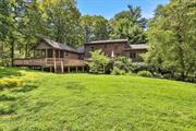 Welcome to your cozy retreat in Dutchess County, just under 10 minutes away from the newly built Eastdale Village, offering shops, restaurants, and a playground. Nestled on 1.7 acres of private land, this unique log home features vaulted beamed ceilings and custom windows that fill each room with natural light.  This 3-bedroom, 3.5-bathroom home includes an oversized family room with a floor-to-ceiling stone fireplace, perfect for gatherings. The large, updated country kitchen, with its expansive center island, leads to a two-tiered deck, ideal for cooking and outdoor dining. The magnificent primary bedroom boasts vaulted ceilings, walk-in his and her closets, an upscale bathroom with a jacuzzi, and access to a multi-tiered wrap-around deck. Upstairs, two spacious bedrooms share a full bathroom. The lower level offers a family room with a wet bar, patio access, a full bathroom, an exercise room, and a two-car garage. The stunning landscaping features stone walls, beautiful trees, plantings, and stone walkways. Enjoy the perfect blend of privacy and convenience, with easy access to town and the Taconic Parkway.