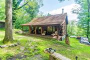 Mountain Top Retreat! Escape to this charming log home, nestled at the end of a private road, surrounded by serene woods that offer ultimate privacy and tranquility. The large rocking chair front porch invites you to relax and soak in the peaceful setting with a view of the spring fed pond. Step into this cozy cabin, where the main level features an open living room with cathedral ceilings and exposed log beams, highlighted by a stunning stone fireplace. The country kitchen, open to the dining and living areas, is both functional and inviting.  A full bath and a comfortable bedroom complete the first floor. The second level includes a bedroom and a loft overlooking the living room, showcasing hardwood floors and vaulted ceilings with more exposed beams. The full walk-out basement with high ceilings offers great potential for additional living space. Enjoy summer nights in the cozy screened-in porch, perfect for sleeping or relaxing. This property is sold with an adjoining 2-acre parcel on a separate deed, including a large detached garage ideal for a workshop or studio, seasonal mountain views. With a total of 3 acres, you have the flexibility to build another home or sell the parcel separately, offering endless possibilities for country living!