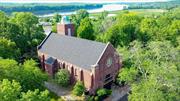 The Abbey, a majestic, 1930&rsquo;s brick church with 8000 sq ft, overlooks the beautiful Hudson River and is still just steps from bustling Warren Street in downtown Hudson, NY - recently called the coolest small town in America.&rsquo;&rsquo;  As you approach the Abbey through the large brick walls and custom electronic iron gate, you are swept away by the architectural beauty and grandeur of this property. In 2016, the current owner undertook a complete renovation - meticulously preserving every detail - from the original glass pendant lights to the gorgeous, original stained-glass windows which surround the main floor. Known as the Sanctuary, this room boasts 30-foot ceilings and has been thoroughly re-imagined while maintaining its pure elegance! You enter the large terrace from this floor which overlooks the property and beautiful, northern views of the Hudson River. The Bell tower also presents many options for future use.  Enter the lower level from one of the two staircases - which features a sprawling professional chef&rsquo;s kitchen with Blue Star appliances and a center island that seats 8 and opens to the large yard. Adjacent to the kitchen is a spacious great room, bracketed by original columns of wood and native stone - the space is perfect for dining and entertaining.  The one full bath and 2 powder rooms are fashioned with beautiful details. The nearly 1-acre property includes a vegetable garden, gorgeous mature trees, and a custom brick, lower terrace perfect for a fire pit and gatherings.  Create the most unique and incredible home in Hudson for you and your family! Or imagine it as a cooking school surrounded by the Hudson Valley&rsquo;s farms or a food television studio and even a music production studio, (the acoustics are professional grade). The Abbey would make for an amazing art center complex or museum, or a Zen meditation retreat. The possibilities are endless.  Beyond all that Hudson has to offer - the new Klocke Estates Distillery is only 10 minutes away; the future home of The Shaker Museum in Chatham is 20 min away and you can be in the Berkshires in 40 minutes. The Abbey is a quick stroll from the historic Hudson Amtrak station - just two hours to NYC and half hour to the Albany International Airport.