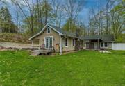 Two bedroom, 2 bath cottage w/an attached guest house emphasizes simplicity & an uncomplicated lifestyle. Ever flowing Wawayanda Creek is part of the magical landscape. Interior was freshly painted with soft natural hues & cozy living room has a charming stone fireplace. Just beyond the living room is a fun, updated kitchen w/vaulted ceilings, range of windows over a porcelain sink & new stove. Renovated bathroom w/tiled shower & whirlpool tub contains a stackable washer/dryer. Principal bedroom with wide board floors & French doors opening to a stream view. 2nd bedroom w/fir floors is currently used as a study. Attached breezeway connects guest quarters w/kitchen and full bath. With plenty of natural light and water views the space is ideal for a home office, fitness center, yoga, or studio. Serene setting to ponder your thoughts! Few minutes to Warwick&rsquo;s trendy Main Street, restaurants, boutiques, library, farmers market, wineries, breweries, hiking, golf, skiing & more. So so charming!