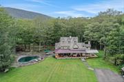 Available for the first time in 50-plus years, this iconic Hudson Valley home boasts extraordinary character and charm in the perfect setting -- a secluded 10-acre nook of ponds and woods just minutes from the Ashokan Reservoir. The house, a masterful blend of timeless farmhouse style, craftsmanship and luxury, is the polar opposite of cookie cutter, with classic window awnings, cedar shakes and locally quarried bluestone steps setting the gracious tone from the moment you pull up a long driveway and arrive at the wrap-around front porch. Inside, a cozy paneled keeping room with a pegged beam ceiling opens to a large and sunny living room and gourmet kitchen, bracketed on one side by an authentic working Rumford fireplace, and on the other by a dining room with a double-height wall of French doors and windows leading to a terraced bluestone patio and pool. Visually, the space opens up, from cozy to dramatic, in thoughtfully calibrated stages that call to mind a distinguished farm house being expanded and improved over many charmed decades of life. The ground floor also includes another beamed den with a double-height ceiling and woodstove, plus a full bathroom and laundry. A stunning open staircase, with a beautiful cherrywood banister milled on site, rises 3 stories to the 4 bedrooms and 2 more full bathrooms upstairs, including a massive primary suite with an oversized bathroom with soaking tub. The other bedrooms, featuring pegged beam framing and dormer windows, are particularly charming. For overflow guests, there&rsquo;s also a separate 2-level guest house with bathroom, overlooking a spring-fed pond, with another larger pond sited just across the winding driveway. Located on one of the quietest and most sought-after roads in the Hudson Valley, the property feels wonderfully secluded, despite being minutes by bicycle from the reservoir and its popular hiking trails, 15 minutes by car from Woodstock and 2 hours from NYC. Additional Information: Amenities:Guest Quarters, ParkingFeatures:2 Car Detached,