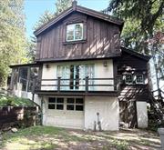 Looking for something different in Douglas Manor!  This property is one of the most unusual in the neighborhood and is known as The Chalet. This is probably one of the most unique Arts and Crafts houses in the historic section of Douglas Manor built by Norwegian decorative artist, Trygve Hammer. His work includes the bas-relief sculptures that adorned the old Bonwitt Teller facade on Fifth Avenue and the Waldorff Astoria Hotel dining room. Hammer and his wife emigrated to New York in 1902 and built the first part of the house, the story and half high living room in 1916. In 1922 the Hammer&rsquo;s expanded it to its current configuration adding the three bedrooms on a second story. The allusion to the mountain chalet is no accident. Hammer modeled his design on a stue, a 17th century farmhouse style indigenous to Setesdal, Norway. Upon entering the front door you&rsquo;ll find an eat-in kitchen with hand crafted cabinets on the right side with a half bathroom to your left. Walking straight ahead you enter a unique parlor with French doors that lead to a balcony overlooking the garden.  To your right you&rsquo;ll find a pair of matching doors that Hammer painted in 1926 in rosemaling, a type of colorful Norwegian folk painting. There&rsquo;s a cozy sitting room with a wood burning fireplace off the parlor which leads to a formal dining room with a door that leads to the backyard. Take three steps up and you enter the very large living room, which was Hammer&rsquo;s original studio. Soaring ceilings with timbers, a large window, a skylight and a large wood burning fireplace finishes off this great entertainment space. There is also a full bathroom off the living room. At the top of the steps on the second floor to your left you&rsquo;ll find the main bedroom with a cathedral ceiling, a large window overlooking the garden and built-in shelving. There are two other bedrooms and a full bath on the second floor. There are plenty of closets and unique storage spaces throughout the rooms. Walking through the house you&rsquo;ll see Hammer&rsquo;s stained-glass windows and many of his Arts and Crafts touches in the rooms. The basement features a studio apartment with a kitchenette and full bathroom. There&rsquo;s also a one-car garage with a large storage room next to it. Hammer surrounded the house with seven Norway spruces to remind him of his native country. The exterior includes darkly stained board and batten siding, a copper roof over the studio and a slate roof over the rest of the house. The focal point of the house is hand carved bargeboards that accent the roofline and vertical corners at the main gable, and the carved decoration at the peak of the house. The house has steam heating and central air conditioning. Over the studio are of the house is copper roofing with slate covering the rest of the house. The Chalet has only had three owners with the current owner purchasing it in 1955. The previous owner was famed commercial illustrator, Earl Oliver.