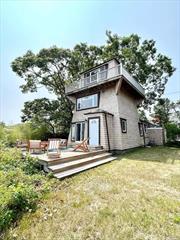 A spectacular location and a unique lighthouse style home, with 3 levels overlooking Shinnecock Bay in the premier bay-front community of East Quogue. Stylishly decorated and furnished, offering exquisite water views from numerous areas of the home, including a ground floor deck with sliding doors to the dining room and kitchen, a large picture window in the primary bedroom, or the wrap-around upper deck complete with breath taking panoramic views from the 3rd floor great room. 2 bedrooms and 2 full bathrooms total, including a spacious primary suite with walk-in closet, a generously sized living room with fireplace for entertaining, and an open kitchen/dining room concept. Offering full access to the large 2 car detached garage. The perfect waterfront getaway during any season!