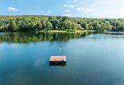 This is Hudson Valley lakefront living on gorgeous and private Upton Lake. The waterfront retreat has 43 feet of frontage on the 46 acre, spring fed, 55 foot deep glacial lake in Clinton Corners, NY. Year long tranquil and picturesque experiences await you here with an abundance of recreation, relaxation, and nature. Thoughtful decking and mature landscaping leads down to the lake, where you access it from the waterfront dock or a floating one nearby. Simply stunning. The decking includes a hot tub + outdoor shower. Entering the home you arrive in a three season, charming screened or windowed front porch. This level includes open kitchen/dining w/ sliders to lakeside decking, small office, laundry and full bath. The upper level includes wall of windowed primary bedroom with cathedral ceiling and ensuite bath. Two other bedrooms are also here. The lower level is living space/den with herringbone flooring, more glass sliders leading to the lakefront magic. A workshop and mechanicals are also on this level. Convenient to the Taconic State Parkway, this is all just 2 hours from NYC. Welcome to the Hudson Valley.