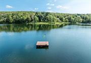 This is Hudson Valley lakefront living on gorgeous and private Upton Lake. The waterfront retreat has 43 feet of frontage on the 46 acre, spring fed, 55 foot deep glacial lake in Clinton Corners, NY. Year long tranquil and picturesque experiences await you here with an abundance of recreation, relaxation, and nature. Thoughtful decking and mature landscaping leads down to the lake, where you access it from the waterfront dock or a floating one nearby. Simply stunning. The decking includes a hot tub + outdoor shower. Entering the home you arrive in a three season, charming screened or windowed front porch. This level includes open kitchen/dining w/ sliders to lakeside decking, small office, laundry and full bath. The upper level includes wall of windowed primary bedroom with cathedral ceiling and ensuite bath. Two other bedrooms are also here. The lower level is living space/den with herringbone flooring, more glass sliders leading to the lakefront magic. A workshop and mechanicals are also on this level. Convenient to the Taconic State Parkway, this is all just 2 hours from NYC. Welcome to the Hudson Valley. Additional Information: Amenities:Pedestal Sink, Stall Shower, Storage, ParkingFeatures: On Street,