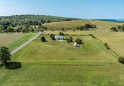 Located on a picturesque road in the scenic Hudson Valley is this country home set amid 5 acres with amazing panoramic views. The main level of the house features an open concept layout. Living room, dining room, and kitchen seamlessly flow together with plenty of space to entertain. Sliding glass doors to the spacious deck, facing north and east, offers a place to relax and enjoy stunning vistas of farmland and rolling hills beyond. Upstairs is finished with three bedrooms and one full bathroom. The lower level offers a light-filled family room with sliding glass door to a lower deck, a half bath, a utility/laundry room, and access to a two-car garage. Many recent improvements. The land consists of 5 acres of lawn and meadow, surrounded by agricultural land and bordered on the east by land in conservation. There is an attractive barn, perfect for storage, a workshop, or raising farm animals. Conveniently located to the Village of Millerton, Pine Plains, and Amenia. Many of the area&rsquo;s best attractions are nearby; Harlem Valley Rail Trail, antiquing, The Moviehouse, Lime Rock, Catamount Mountain, Taconic State Park - Rudd Pond Area hiking trails, and some of the best restaurants in the Hudson Valley. The Metro-North train station is just a 15 minute drive.