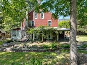 This charming farmhouse on Hasbrouck Road is framed by the timeless beauty of the nearby Shawangunk Ridge, a haven for hikers, climbers and nature lovers. Adding to the sense of place, stones from the property are incorporated into the living room fireplace and the artful stonework found outside the home--patios, walkways, tiered stone walls and garden beds. The exterior is a mix of stone and cedar shingle siding, and the standing seam metal roof was installed by the current owners. Dating back to 1853, the house has the details you&rsquo;d expect--wide wood floors, original mouldings, paneled doors with vintage knobs, and built-ins. The windows are modern, but maintain the period look with 6-over-6 divided light. In the kitchen you&rsquo;ll find timeless custom cabinets with glass doors and patinaed brass latches and cup pulls, bluestone and butcher block countertops, a 6-burner Jenn-Aire gas range, and a rustic ceramic tile floor. Off the kitchen is a mudroom with french doors and a half bath. A cozy dining room, living room with working fireplace, and south-facing sunroom round out the first floor. Upstairs there&rsquo;s a colorful wardrobe at the second-floor landing, 3 bedrooms, an office and a full bathroom with stacked washer/dryer. The walk-up attic is unfinished and currently used for storage. Ornamental vines adorn the covered front porch, which looks out to the shed and gently sloping lawn. Wood privacy fencing encloses the main portion of the 3.59 acre property and includes a convenient gate to the road and double swing gate to the driveway. Nearby Mohonk Preserve and Minnewaska State Park offer year-round recreation in nature (hiking, biking, swimming, skiing), and local farms grow seasonal goodness (Jenkins-Leuken Orchard, Tweefontein Farm, Wallkill View). The villages of New Paltz and Gardiner are close at hand for dining, shopping and other amenities. Call to book a showing today.