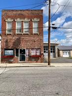 Earn 12% return on investment or a lot more. Great Historic brick building on Front Street in the Renaissance City of Port Jervis. This Huge 3500 square foot building is Active Business downstairs and two modern residential apartments upstairs. Walk to NYC Trains. Would be Great as an Air B&B which would bring the CASH in hand over fist. As is now Business pays $2200 per month and apt bring in $2700 for $4900 gross oer month of $58, 000 gross per year. Net return on Income is $48, 000 per year as tenants pay water sewer and utilities.