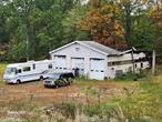 The town will allow the garage to be rebuilt on the same footprint and configuration: an apartment in the rear and a three-bay garage in the front. They also will allow the brick house on the hill. 5.8 acres with two drilled wells and 2000 gal. Septic tank. An existing 2400 sq. ft. three-bay garage suffered from a fire in 2018. A brick house sits on the hill, which needs total renovation. In addition, the building is unsafe to enter. The storage trailers are also for sale through a separate agreement. The property is zoned R1A, but it was zoned as Industrial before recent zoning changes.