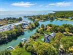 Experience the epitome of coastal country living in this newly constructed, quality craftsmanship waterfront home on James Creek, leading to Peconic Bay. With 80 feet of prime waterfront and approved plans for a Dock accommodating up to a 46&rsquo; boat, this home showcases a classic Hamptons Dutch roof line, Hardie cedar siding, Azek trim, along with an attached garage. The thoughtfully landscaped grounds of hydrangeas, boxwoods and seagrasses also feature a bluestone patio that surrounds a refreshing saltwater pool complete with an outdoor shower. Step inside to discover an inviting open floor plan, highlighted by generous 10-foot ceilings with crown molding, and warm 5-inch white oak floors.The gourmet kitchen with large butlers pantry boasts stunning quartz countertops, wood shaker cabinets and high end Italian Bertazzoni appliances, seamlessly flowing into the dining and living areas bathed in natural light from wall-to-wall windows and sliders. The living room, with its shiplap accent wall and gas fireplace, creates a cozy yet sophisticated atmosphere. The main level also includes a versatile formal dining room that can double as a home office, a Jr.en-suite, and a functional mudroom with laundry and a half bath, leading to the garage designed for the option of a car lift. Ascend the double wide staircase with wall moldings to the second level, where you will find a welcoming open den, a luxurious primary en-suite behind double doors with large sliders opening to a private deck overlooking the tranquil waterfront. There is a third en-suite bedroom, two additional bedrooms, another full bath and second laundry room complete this level. Surrounded by charming farm stands, exquisite wineries, beautiful beaches, and delightful restaurants, this stunning coastal home in Mattituck captures the coveted lifestyle of Long Island&rsquo;s East End.