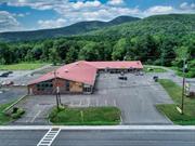 This strip plaza is located on State Route 28, with a daily traffic count of 7, 000 vehicles. It is situated at the gateway to the Catskills and offers over 42, 000 square feet of commercial space. The plaza consists of a large commercial building and 4 attached stores/service shops. It is conveniently located next to the area&rsquo;s largest grocery/shopping center and across the street from the local high school. The high-traffic location ensures year-round business from surrounding homeowners, skiers, tourists, and local development. The property is in very good condition and has municipal sewer access. The large commercial space, previously used as a lumber yard and salvage retail store, offers over 35, 000 square feet of office, retail, and warehouse space with excellent visibility from State Route 28. The building has updated systems, including the roof, heating, and cooling units. The tenant base is solid, with a Post Office, Restaurant, Woodstock Antiques, and cafe/catering already occupying the space. The vacant large commercial storefront with warehouse space is available for lease at $4, 500 per month. For potential buyers, it&rsquo;s important to note that the sale of the building comes with a non-compete restriction for the grocery business next door for 10 years. At the asking price with the vacant large commercial space, the Cap rate is approximately 6%. Please refer to the associated documents for more information on income and expenses related to the property. Additional Information: ParkingFeatures:1 Car Detached,