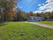 Welcome to Rose Rd, a quiet and peaceful rural setting shared with deer and chipmunk neighbors. This manufactured home sits back on a little less than an acre with charming stone walls, lush grass and lots of space for your gardens, a firepit, playground or new deck. The paved driveway and shed are great bonus features. Inside you will find a spacious living room with open flow into an eat in kitchen with an abundance of windows. Each of the two bedrooms and full bathrooms are located on either side of the home, creating privacy and space. The primary bedroom features a large walk in closet and an ensuite with large bath tub. A laundry room with cabinets for storage is conveniently located off the kitchen, on the way to the back door. There are several closets and cabinets for storage throughout. The higher ceilings and well thought out flow make this home a gem, with a ton of potential! It is ready for the next owner to make it shine.