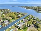 Located within the exclusive Old Harbor Colony Community in Hampton Bays, this stunning waterfront property offers a picturesque escape with luxurious amenities. Boasting 120 feet of bulkheading on a scenic canal, the residence features a 50-foot dock, providing the perfect setting for boat enthusiasts and water lovers. The expansive home, thoughtfully designed with a focus on comfort and functionality, includes a total of four bedrooms including a well-appointed in-law suite, offering versatile living arrangements. The main living space includes a primary suite, featuring a spacious walk-in closet for added convenience and two additional guest bedrooms. With a private entrance, enjoy seamless living in the separate guest wing equipped with one bedroom, a den and an office. Step into the heart of the home, where an open floorplan seamlessly integrates the kitchen and living room, creating an inviting space for both entertaining and everyday living. The kitchen is equipped with modern appliances and ample counter space, making it ideal for culinary enthusiasts. Beyond the interior, the property&rsquo;s grassy backyard is a private oasis, complete with an irrigation system to maintain the lush greenery. This meticulously maintained residence not only offers a comfortable and stylish living environment but also provides access to the tranquility of waterfront living in one of Hampton Bays&rsquo; most coveted communities. Step outside to discover a private oasis with ample shaded areas around the pool, a two-car garage, and an outdoor shower for added convenience. The meticulously designed landscape is enhanced by Lexor lighting, creating a sophisticated ambiance. The property is equipped with a Sonos sound system, providing seamless audio enjoyment indoors and outdoors. This residence offers not only waterfront living in a coveted community but also a lifestyle marked by comfort, convenience, and modern luxury., Additional information: Interior Features:Guest Quarters, Lr/Dr