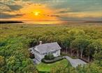 Situated on 2.85 acres of peaceful bliss, this picture perfect spacious 4 bedroom, 4 1/2 bath Classic Hamptons shingle style home checks all the boxes for a country getaway or full time residence in the heart of the Hamptons with 24/7 water vistas and show-stopping sunsets. Gorgeous Little Peconic Bay and Noyac Bay water views are featured from almost every room. Enjoy many dining experiences with open dining inside or dining outside on the show stopper waterside porch overlooking the pool, tree tops and the bay. The primary bedroom is on the main level along with the soaring ceiling living room, a new gas fireplace, dining area and newly renovated kitchen. Steps down to ground level, the expertly crafted home includes 3 additional generously sized bedrooms and a fourth room that could be used as a den, media room, office or bonus room and two full baths. French doors lead outside to the outdoor living room /kitchen and to the 44x20 heated gunite pool. The lower level has an office, gameroom , bar area , a full bath and 2 car garage. Room for expansion. Close to Sag Harbor Village, Southampton and Bridgehampton, pristine white sand ocean beaches, Foster Memorial Long Beach, marinas and inlets with boat launches.