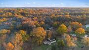 Nestled along the tranquil banks of the Shawangunk Kill River, this enchanting home on 11.4 acres isn&rsquo;t just a residence it&rsquo;s a living storybook where each day unfolds with wonder and serenity, just a scenic 1.5-hour drive from New York City. Imagine waking to the gentle glow of morning light filtering through the trees outside your bedroom window. Just beyond the glass, your horse grazes peacefully, its mane catching the first rays of sun. Nearby, your loyal dog playfully darts about, the two animals sharing a bond that mirrors the harmony of this place. The sight warms your heart a daily reminder of the simple joys that come with living so intimately connected to nature. Stepping onto the deck with a steaming mug in hand, you&rsquo;re greeted by the flutter of hummingbirds and the graceful stride of deer wandering through your yard. The air is crisp and filled with the soft sounds of the wilderness waking up. Here, morning meditation feels effortless, a natural extension of the tranquility that surrounds you. The house itself is a masterpiece of timeless craftsmanship. As you wander through its rooms, the warm, cozy ambiance embraces you. Hand-hewn beams held together by handmade nails tell stories of a bygone era, each one a testament to the artisans who built this home with care and intention. In the basement, an old stone area hints at what might have once been the original kitchen a charming nod to the home&rsquo;s rich history. Unique touches like the whimsically crooked door in the kitchen add character, making every corner of this house feel special and lived-in. Your days here are a blend of peaceful solitude and joyful community. The expansive yard becomes a playground where little ones laugh and chase, their footsteps weaving memories into the very soil. Afternoons are perfect for leisurely walks to the river, the path shaded by towering trees and accompanied by the soothing sounds of flowing water. Perhaps you prefer more adventurous pursuits hiking the trails of the nearby Shawangunk Ridge, where panoramic vistas reward your efforts. The surrounding area offers delights for every interest. A stroll by the creek leads you to local wineries, where tastings become a favorite weekend ritual. The vibrant town of Pine Bush is close by, its streets coming alive with festivals, farmer&rsquo;s markets, and holiday parades that foster a strong sense of community. Here, neighbors aren&rsquo;t just people who live nearby they become friends who share in the celebrations of life&rsquo;s simple pleasures. As the day winds down, the tradition of meeting the school bus at the end of the road becomes a cherished routine. The golf cart ride back home is filled with the excited chatter of little ones, their stories and laughter filling the air. Evenings are spent on the patio, where you can watch the full moon rise over the treetops, casting a silvery glow across your private sanctuary. It&rsquo;s a moment of magic a quiet pause to reflect on the fullness of life in this special place. Pets thrive here, just as the people do. The ample space provides endless opportunities for exploration and play, making it a haven for all members of the family, two-legged and four-legged alike. This home is more than just a dwelling; it&rsquo;s a tapestry of experiences woven together by the threads of nature, history, and love. It&rsquo;s the warmth of a stone foundation beneath your feet and the whisper of old stories held within hand-hewn beams. It&rsquo;s the feeling of being exactly where you&rsquo;re meant to be. Located just approximately 75 miles from New York City, this idyllic retreat offers the perfect balance of seclusion and accessibility. Now, this story awaits its next author. Is it you? Step into this world and begin the next chapter of your life, where every moment is a memory in the making.