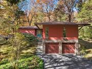 Mid-Century Modern home located on a private road in Wappingers Falls was designed by architect David Henken, an associate of Frank Lloyd Wright. Henkenâ€™s work in the Usonia community in Westchester County is well-documented and highly sought after for its clean lines and seamless indoor-outdoor living. Tucked away on a road in a well established neighborhood with only 6 homes, the property is nestled on 2.09 serene acres, creating a tranquil oasis while still being conveniently located near Rt. 9, schools, shops, Metro North train station and restaurants. As you enter this home you will notice the floor to ceiling windows in the living room/dining area which creates a natural harmony between the interior and outside. The wood burning fireplace surrounded by ledge stone and warm mahogany woodwork enhance the homeâ€™s appeal. The updated, spacious eat-in kitchen with plenty of oak cabinets, boasts granite countertops, SS appliances, subway tile backsplash. The media room has been insulated for sound. The first of 3 bedrooms is currently being used as a library/office. A hallway with full bath and laundry room leads to 2 additional bedrooms, one of which is the primary suite featuring lots of windows, hardwood floors and a cedar lined closet. The ensuite has a Jacuzzi tub, walk-in shower and an enclosed water closet. Enter the large 2 car garage from the outside, walk to the back to find the mechanicals and space for a wine cellar. This is a four season property with each season displaying memorable landscapes, including spectacular sunsets. If you are a design enthusiast or simply appreciate the aesthetics of a well built living space, this architectural Mid-Century Modern gem may just be your style!