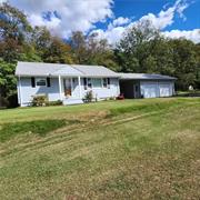 This charming 2-bedroom ranch is located in a peaceful community just outside of Port Jervis. It offers a convenient location close to all amenities and features a lovely yard, great for outdoor barbecues and entertaining. Neighborhood is perfect for leisurely walks or kids riding bikes. The home includes a full bath and an eat-in kitchen with Pergo flooring. You&rsquo;ll appreciate the spacious living room and the hardwood floors in the bedrooms, hallway, and living room. Partial family room and laundry area in full basement. Additional highlights include a paved driveway, a 2-car garage, and a pleasant breezeway. It&rsquo;s a perfect blend of comfort and functionality!